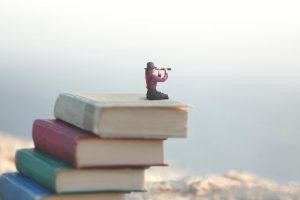 Femme miniature assise sur des livres avec des mots intraduisibles